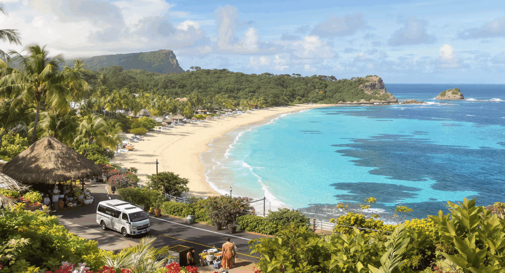 Panoramic view of Natadola Beach on Fiji’s Coral Coast with turquoise waves, palm-fringed white sand, and clear skies — featured in the Discover Coral Coast Tour.