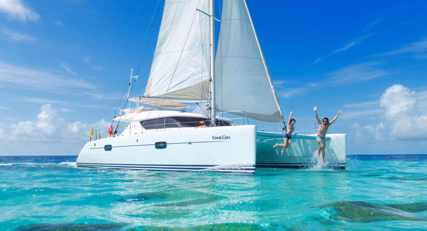 Guests jumping into crystal-clear water from a Coral Cats sailing catamaran in Fiji under a sunny sky